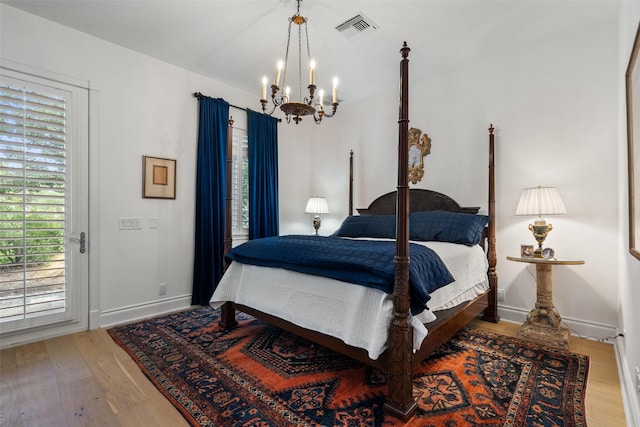 bedroom with a notable chandelier and hardwood / wood-style floors