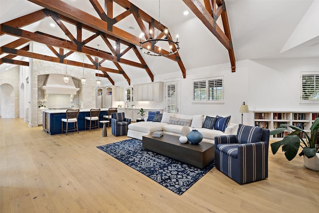 living room with light hardwood / wood-style flooring, beam ceiling, high vaulted ceiling, and a notable chandelier