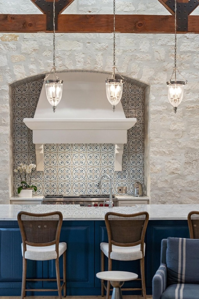 kitchen featuring decorative light fixtures, a towering ceiling, and blue cabinets