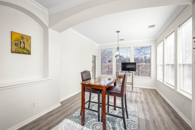 dining room featuring plenty of natural light, hardwood / wood-style flooring, and ornamental molding