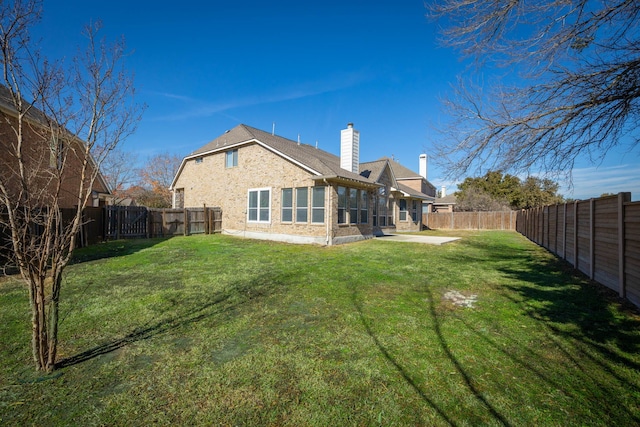 rear view of property featuring a lawn and a patio