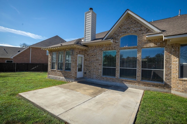 back of property featuring a patio area and a lawn