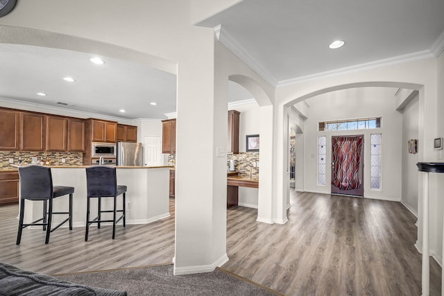 foyer with crown molding and light wood-type flooring