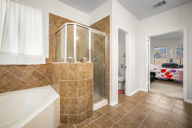 bathroom featuring toilet, independent shower and bath, and tile patterned flooring