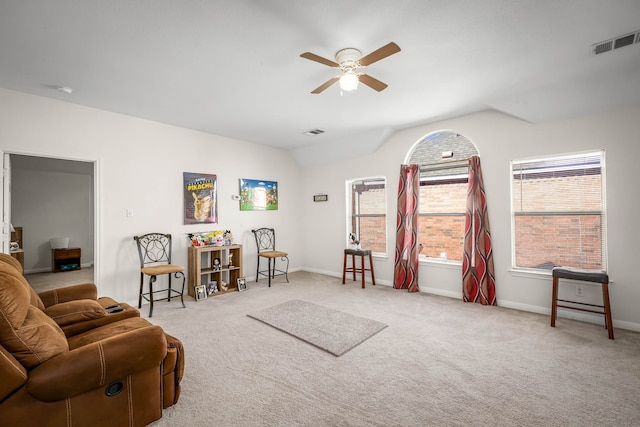 sitting room with lofted ceiling, light carpet, and a wealth of natural light