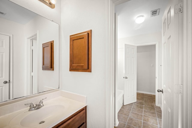 bathroom featuring a tub, tile patterned flooring, and vanity