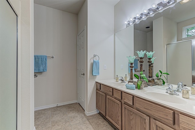 bathroom with a shower with door, tile patterned floors, and vanity