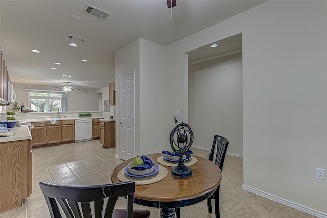 dining area featuring ceiling fan, sink, and light tile patterned flooring