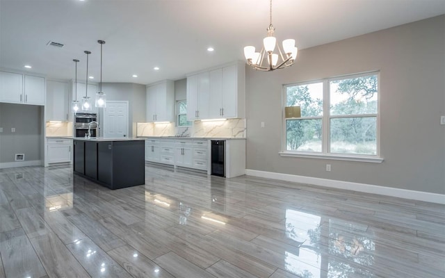 2718 Leslie Ln, San Marcos, TX 78666 - kitchen with wine cooler, light countertops, white cabinets, backsplash, and a chandelier