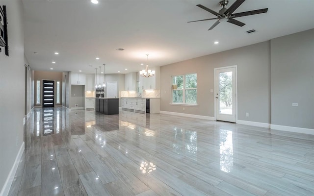 2718 Leslie Ln, San Marcos, TX 78666 - unfurnished living room featuring a chandelier, light wood-style floors, recessed lighting, ceiling fan, and beverage cooler