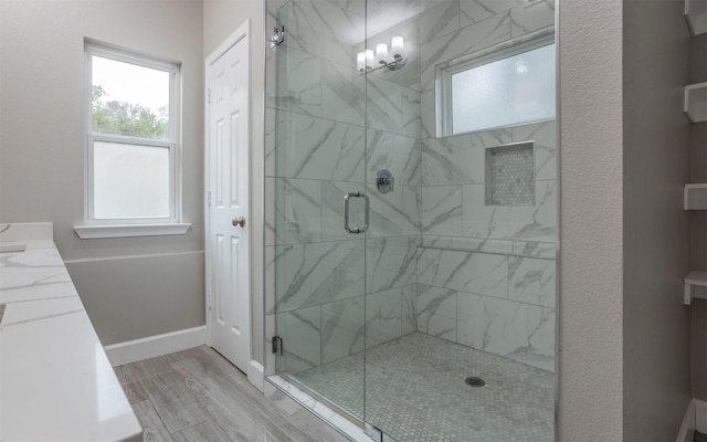 bathroom with wood-type flooring, a shower with door, a chandelier, and vanity