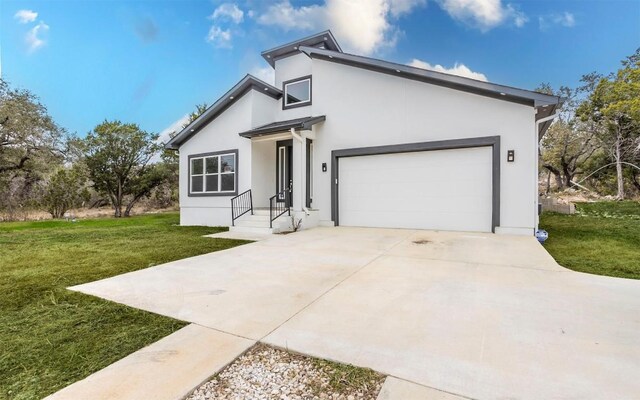 2718 Leslie Ln, San Marcos, TX 78666 - view of front facade with a front yard, driveway, stucco siding, and a garage