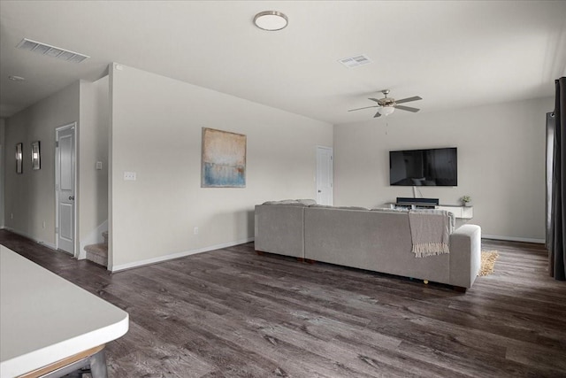 living room featuring ceiling fan and dark hardwood / wood-style floors