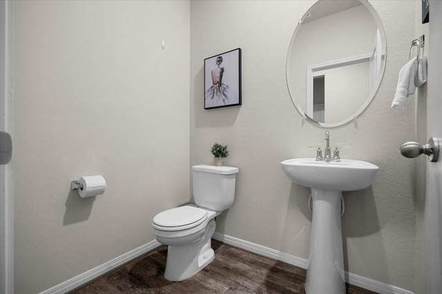 bathroom featuring hardwood / wood-style floors and toilet