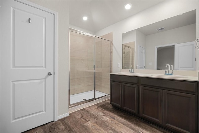 bathroom featuring vanity, hardwood / wood-style flooring, and a shower with door