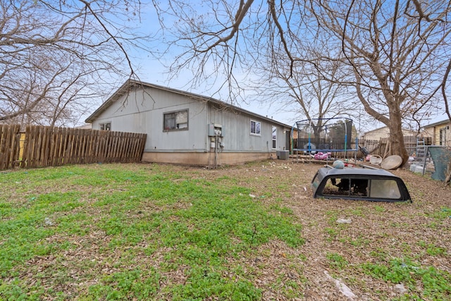 exterior space with a trampoline, a lawn, and central AC