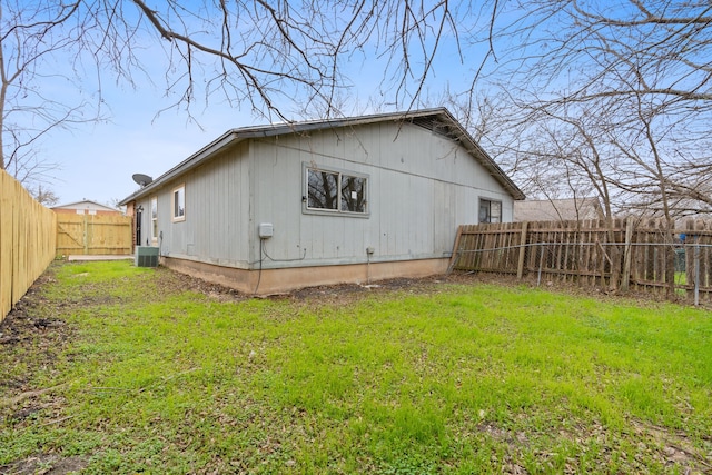 back of property featuring a lawn and central air condition unit