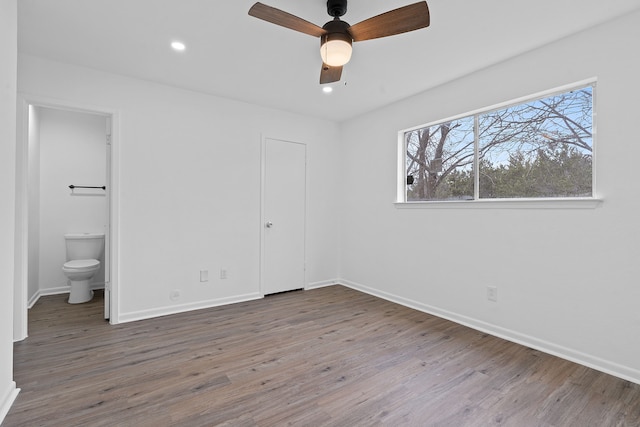 unfurnished bedroom featuring ceiling fan, connected bathroom, a closet, and hardwood / wood-style floors