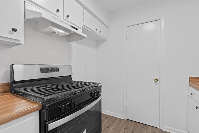 kitchen with stainless steel gas range oven, white cabinetry, and light hardwood / wood-style flooring