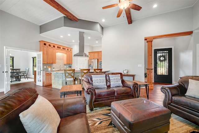 living room featuring sink, ceiling fan, beam ceiling, and light hardwood / wood-style floors