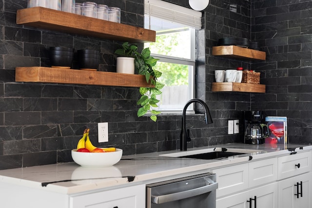 kitchen featuring sink, backsplash, stainless steel dishwasher, and white cabinets