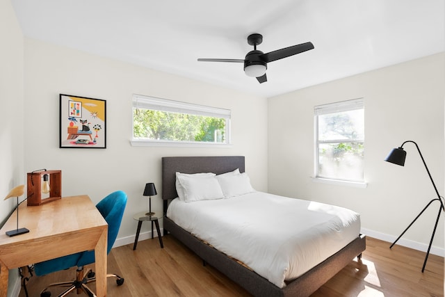 bedroom with multiple windows, light hardwood / wood-style flooring, and ceiling fan