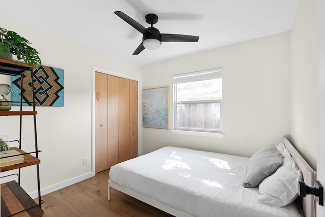 bedroom with ceiling fan, wood-type flooring, and a closet