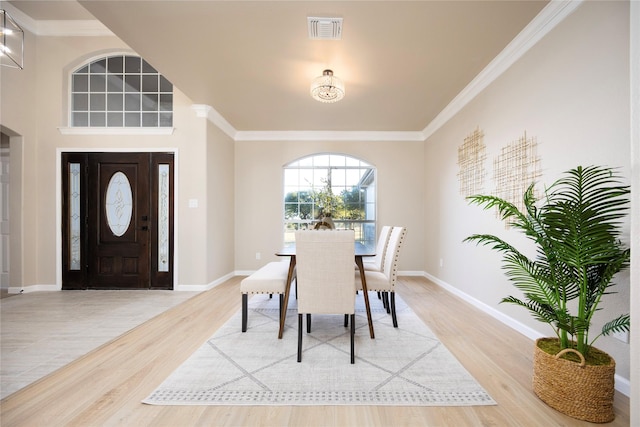 dining area with wood-type flooring and ornamental molding