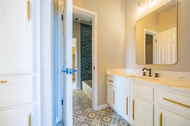 bathroom featuring a bathtub, vanity, and tile patterned flooring