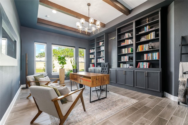 office space featuring a notable chandelier, built in shelves, and a raised ceiling