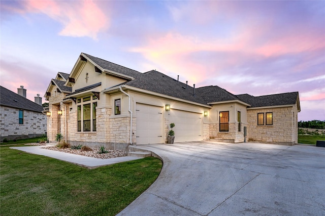 view of front of property with a garage and a lawn