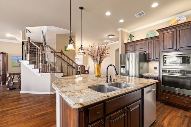 kitchen with sink, crown molding, stainless steel appliances, a center island with sink, and decorative light fixtures