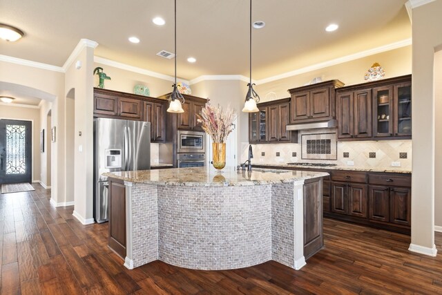 kitchen with pendant lighting, sink, dark brown cabinets, and appliances with stainless steel finishes