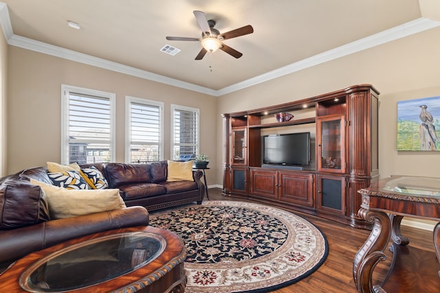 living room with ceiling fan, visible vents, dark wood finished floors, and crown molding