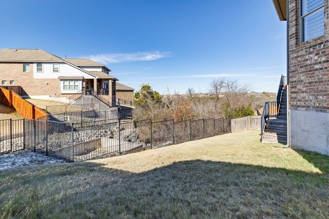 view of yard featuring stairs and a fenced backyard