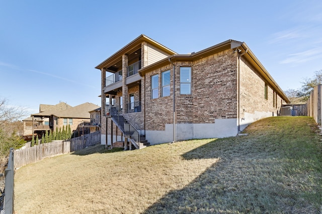 view of home's exterior featuring a lawn and a balcony