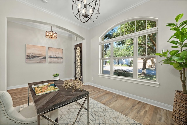 interior space with hardwood / wood-style floors, crown molding, and an inviting chandelier