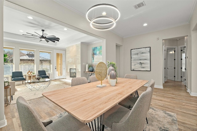 11716 Shadestone Ter, Austin, TX 78732 - dining room featuring light wood finished floors, ornamental molding, baseboards, a high end fireplace, and recessed lighting