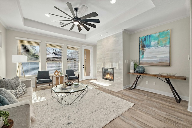 11716 Shadestone Ter, Austin, TX 78732 - living area with a tray ceiling, wood finished floors, ornamental molding, a fireplace, and baseboards