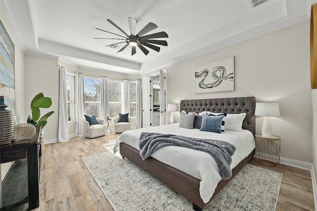 11716 Shadestone Ter, Austin, TX 78732 - bedroom featuring a tray ceiling, baseboards, light wood-type flooring, a ceiling fan, and ornamental molding