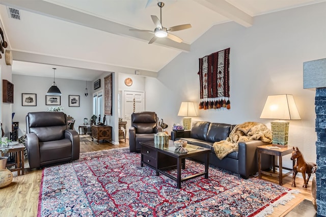 living room featuring ceiling fan, wood-type flooring, and vaulted ceiling with beams