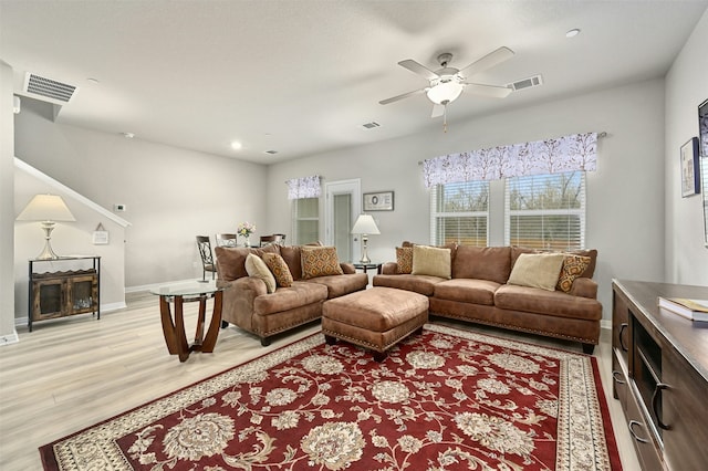 living area with light wood-style flooring, visible vents, and baseboards