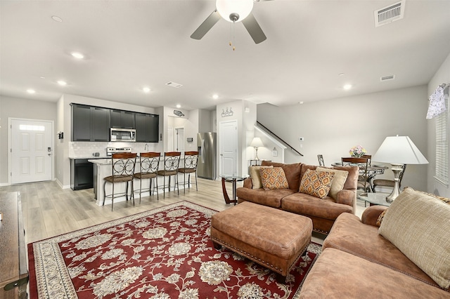 living room with ceiling fan and light hardwood / wood-style floors