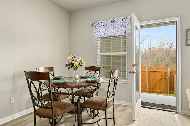 dining room featuring light wood-type flooring and baseboards