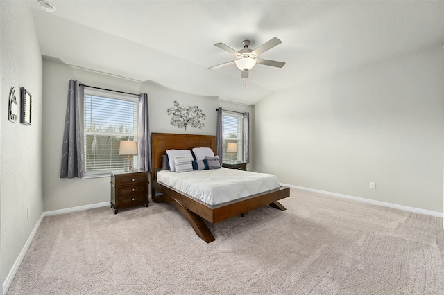 bedroom featuring multiple windows, ceiling fan, light carpet, and lofted ceiling