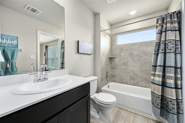 full bathroom with a textured ceiling, toilet, vanity, and shower / bath combination with curtain