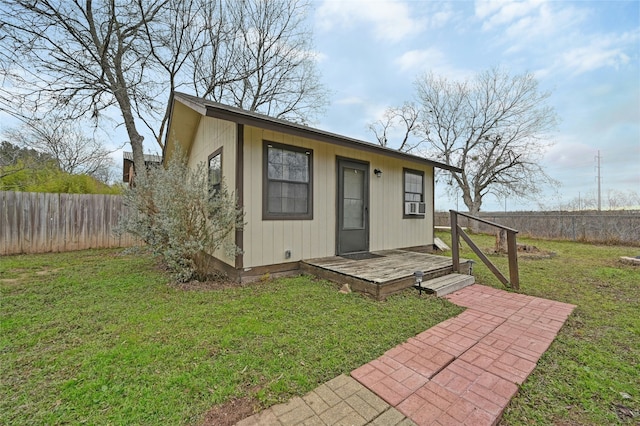 view of front facade featuring an outbuilding, cooling unit, and a front lawn