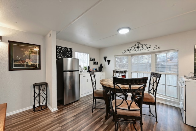 dining room featuring a healthy amount of sunlight and dark hardwood / wood-style floors