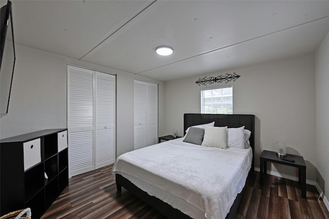 bedroom with multiple closets and dark hardwood / wood-style flooring