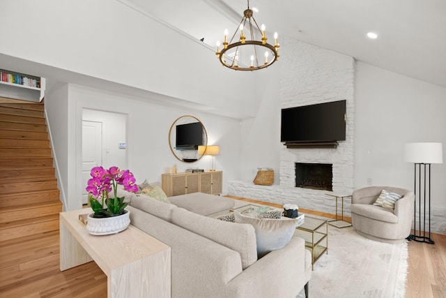 living room with light hardwood / wood-style floors, high vaulted ceiling, and a fireplace